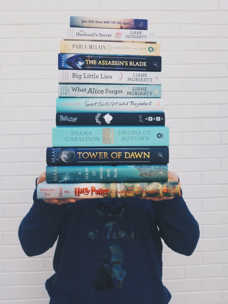 Girl holding a stack of books