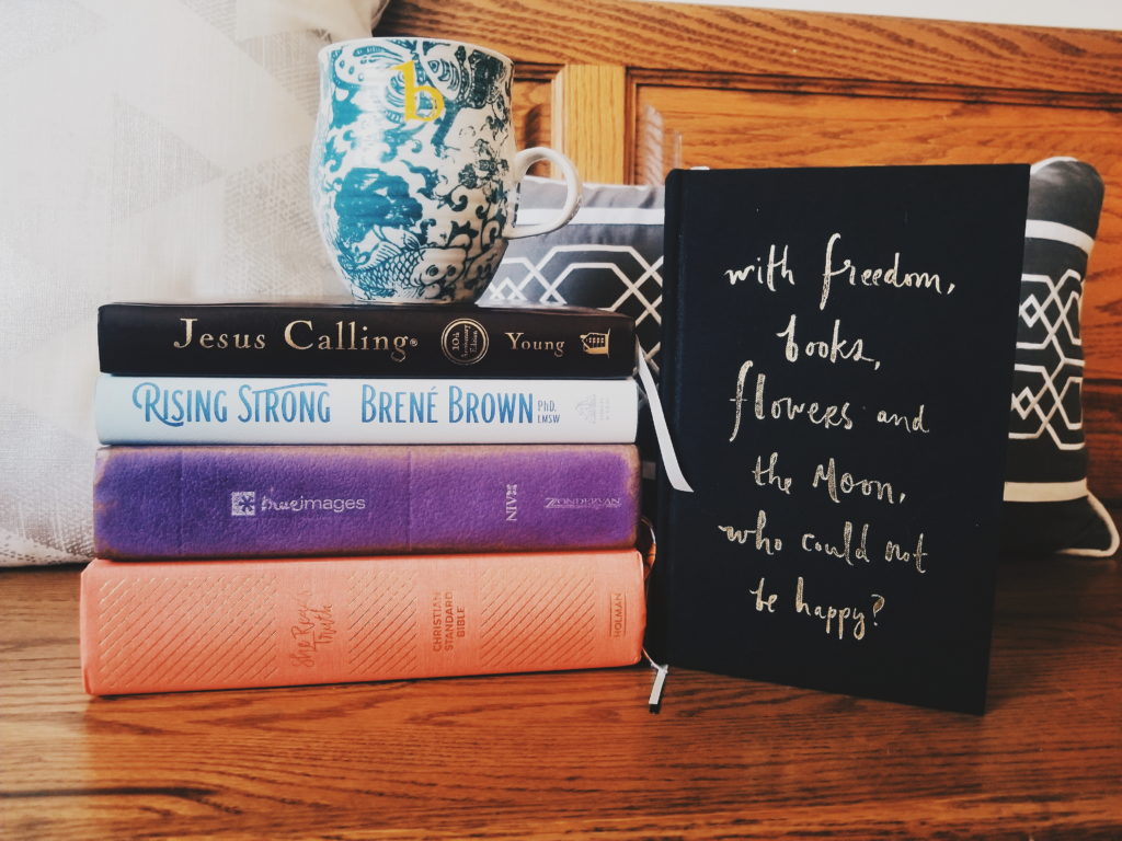 Stack of books used for my morning quiet time routine with the Lord, with coffee on top and a book standing up right with the quote "with freedom, books, flowers, and the moon, who could not be happy?"