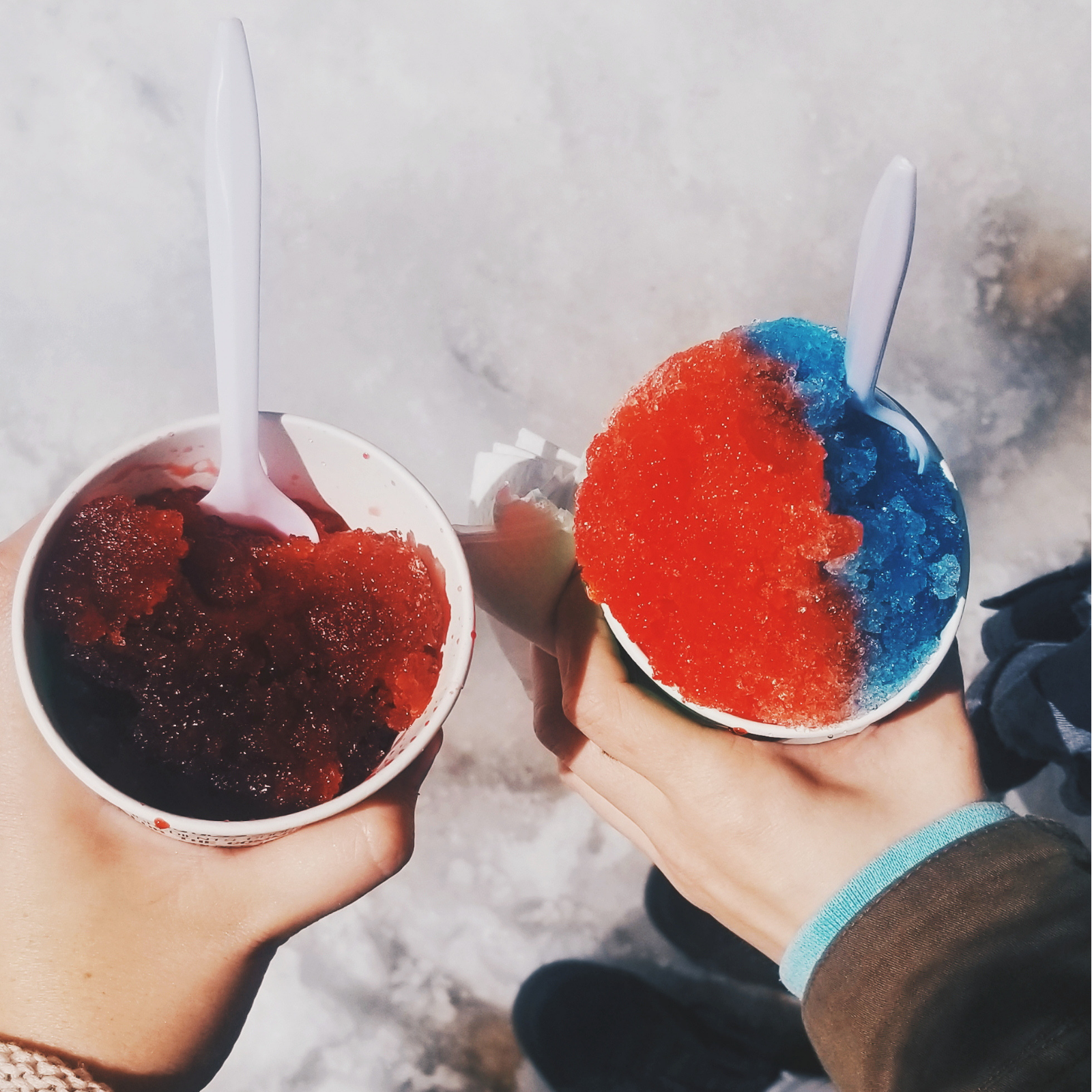 Snow cones being held above snow