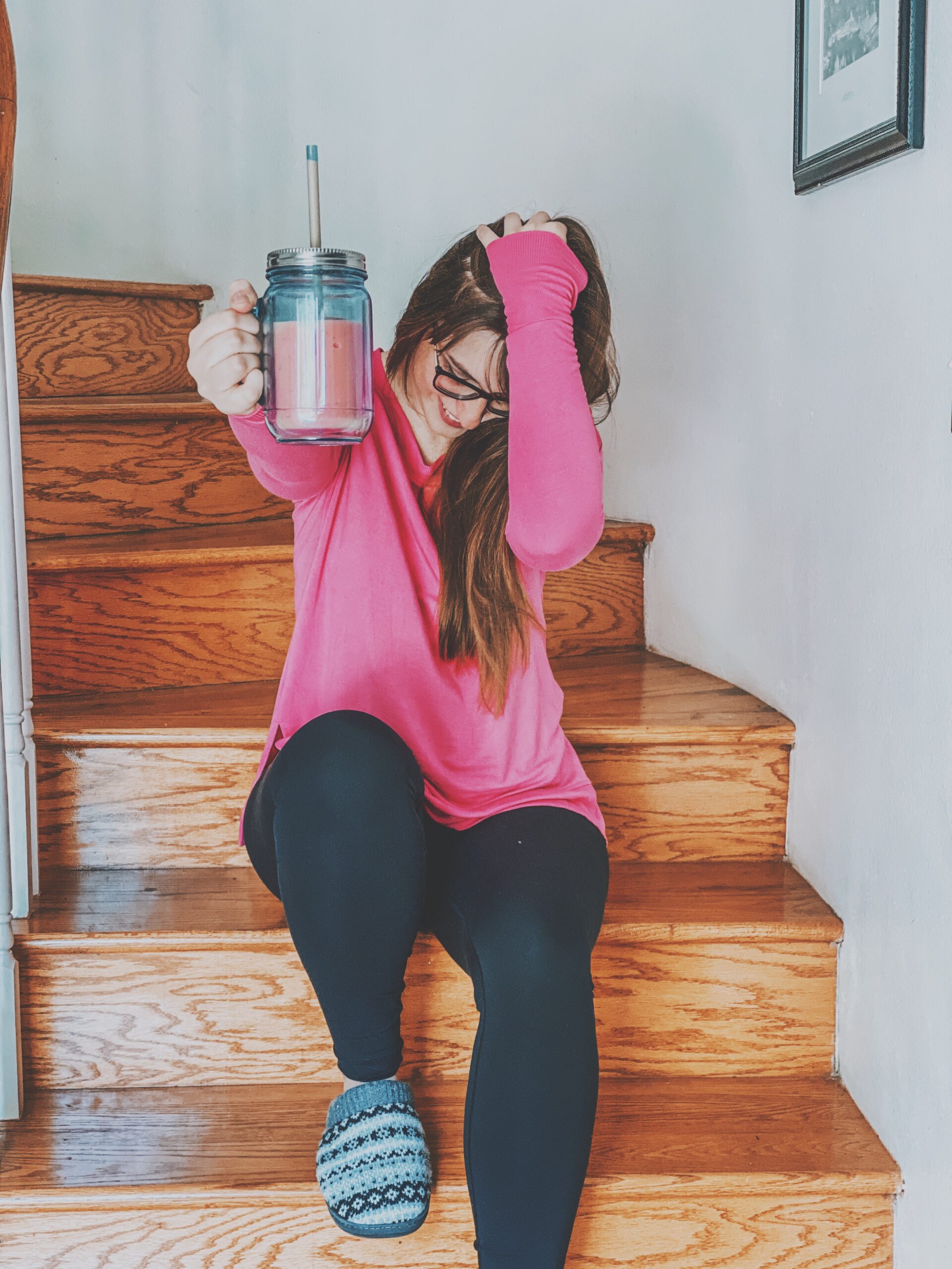 Girl holding up a pink smoothie